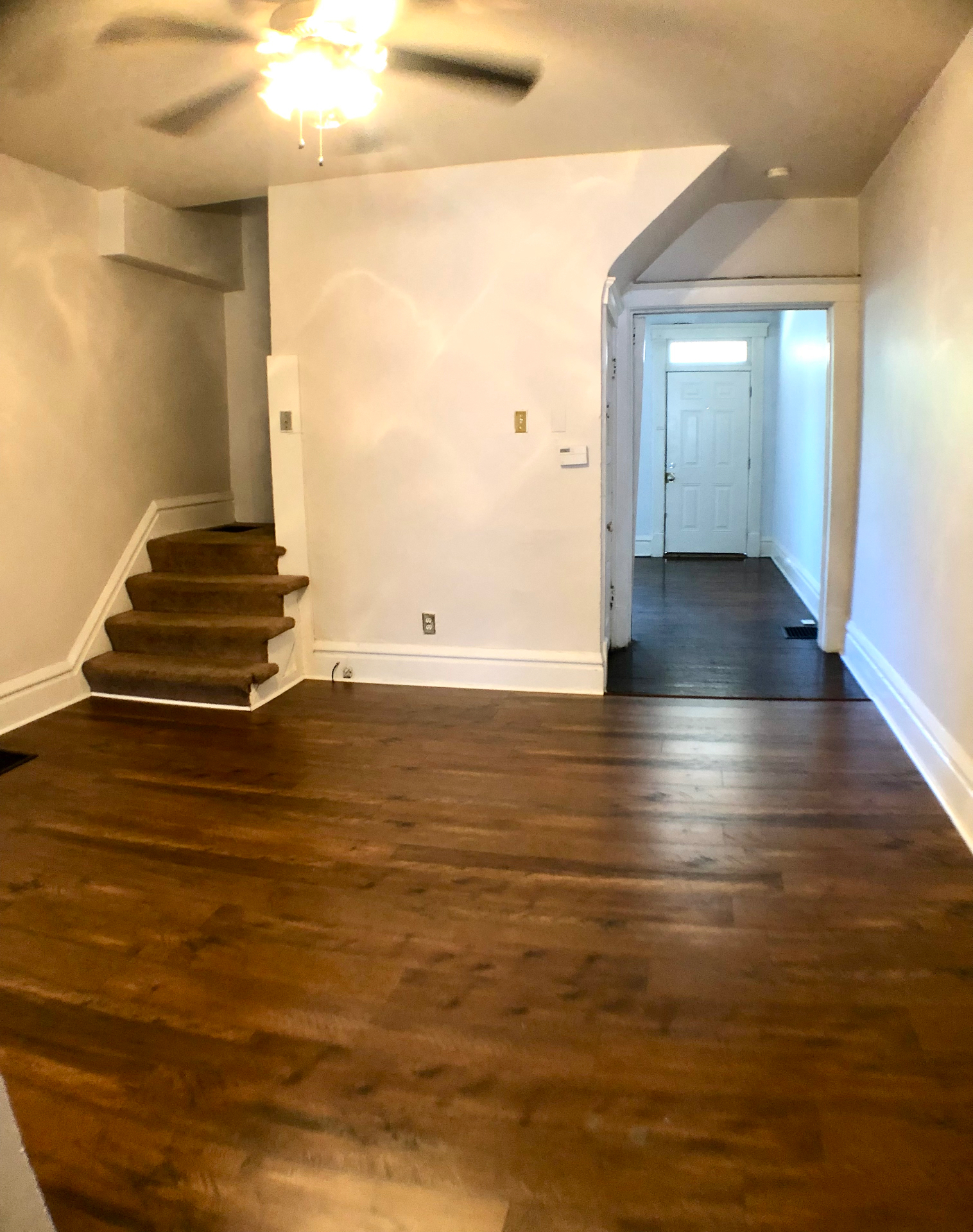 117 W 9th entry with refinished dark hardwood floors and staircase