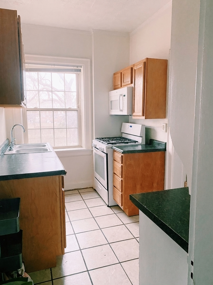Unit H galley kitchen with gas range, microwave, and double sink