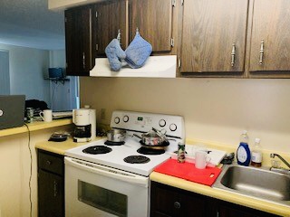 2026 Summit St. kitchen with dark wood cabinets, electric range, and breakfast-bar counter