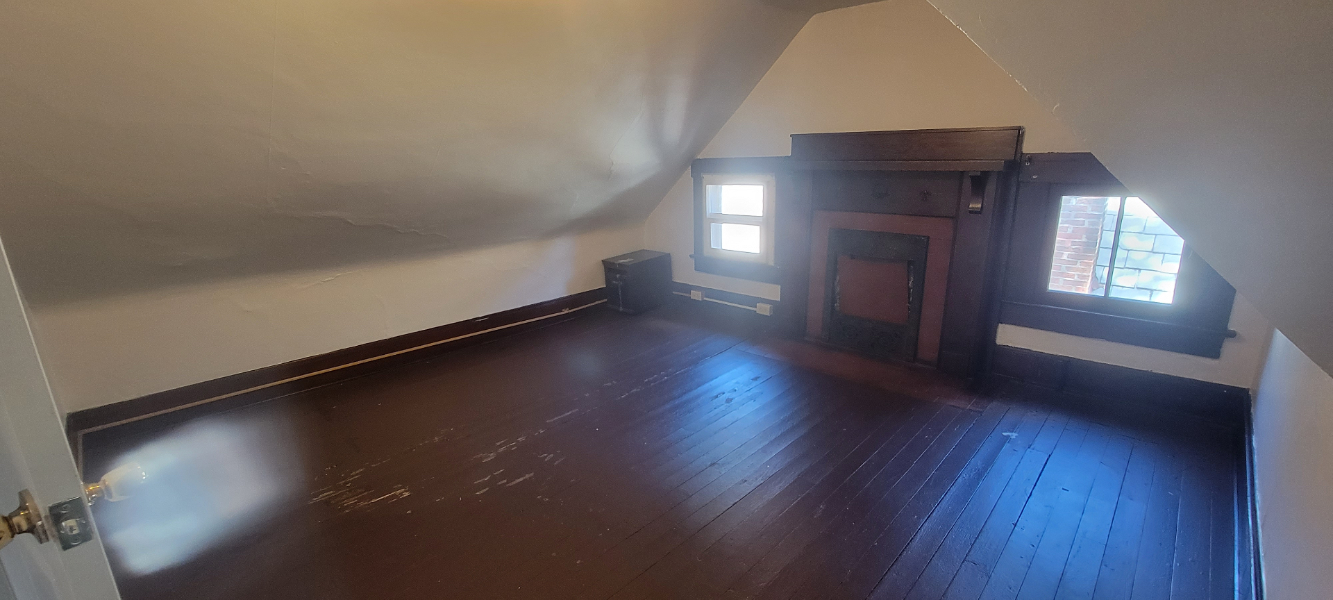 2015 Summit St. third-floor bedroom with decorative fireplace, dormer windows, and hardwood floors