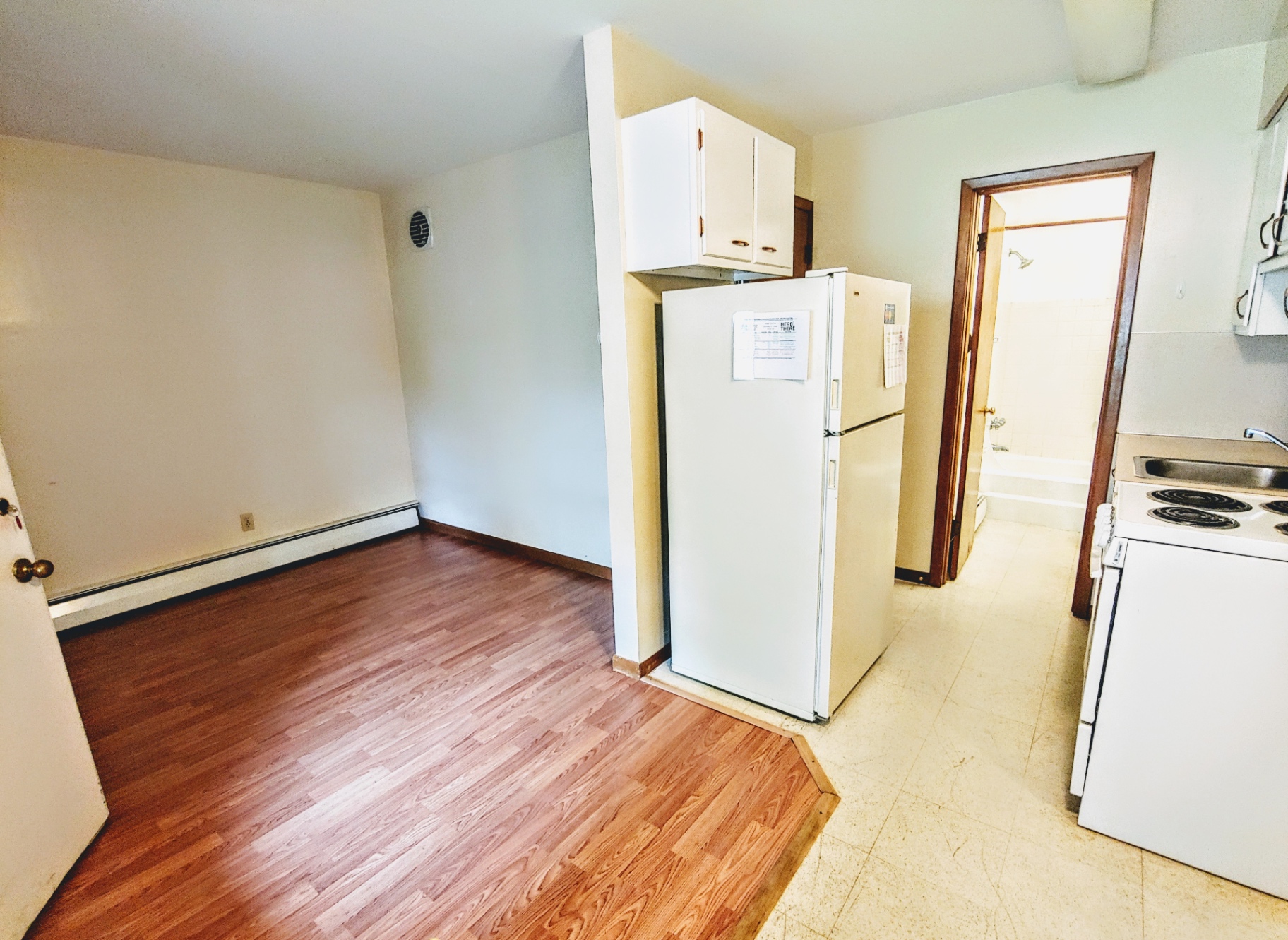 2040 Iuka Ave. 4A compact kitchen with electric range, full-size refrigerator, and white cabinetry