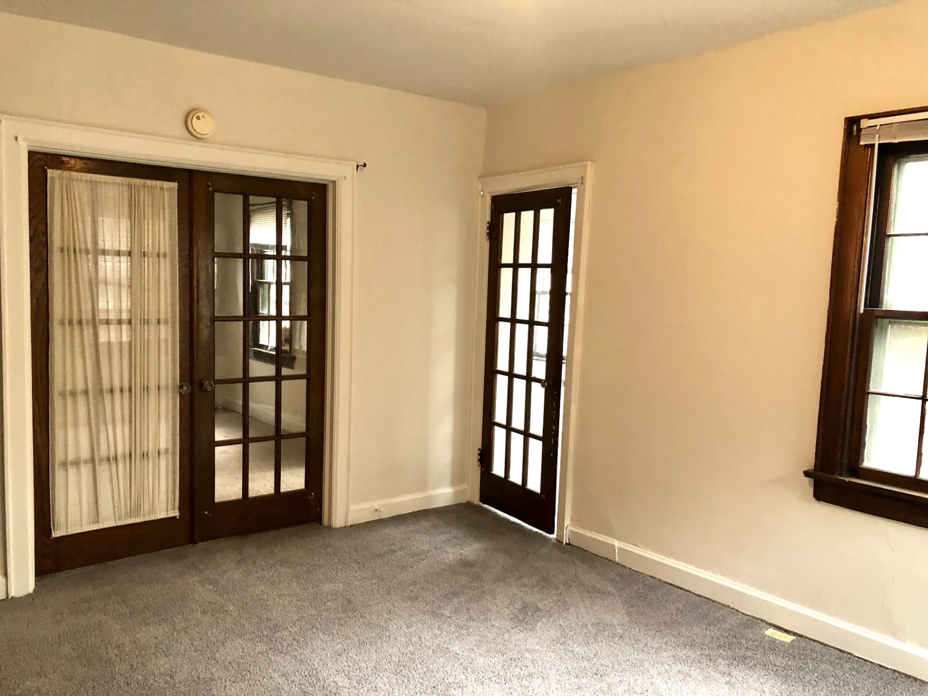 2044 Iuka Ave. B carpeted room with dual French-door entries and wood-trim window