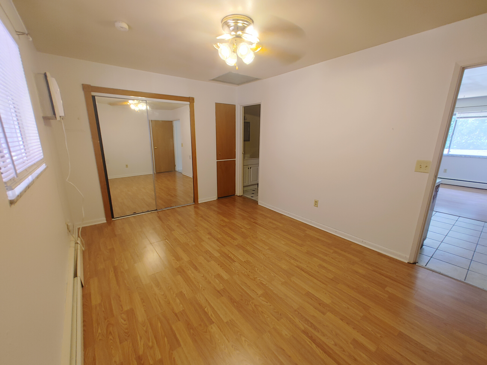 1827 N 4th St. Unit 5 bedroom with wood-look flooring, ceiling fan, and en-suite bath access