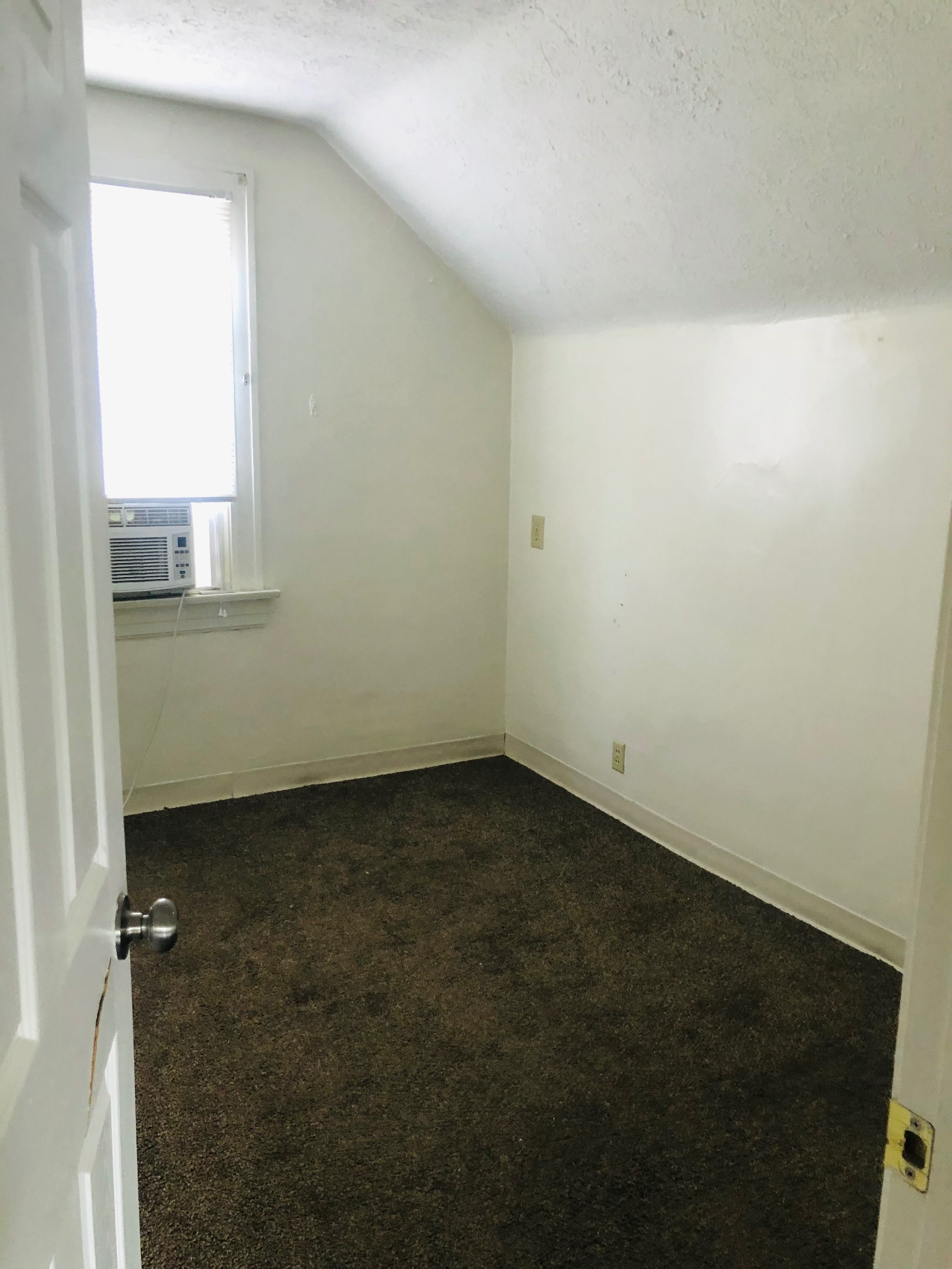 2005 Summit St. upstairs bedroom with sloped ceiling and window air conditioner