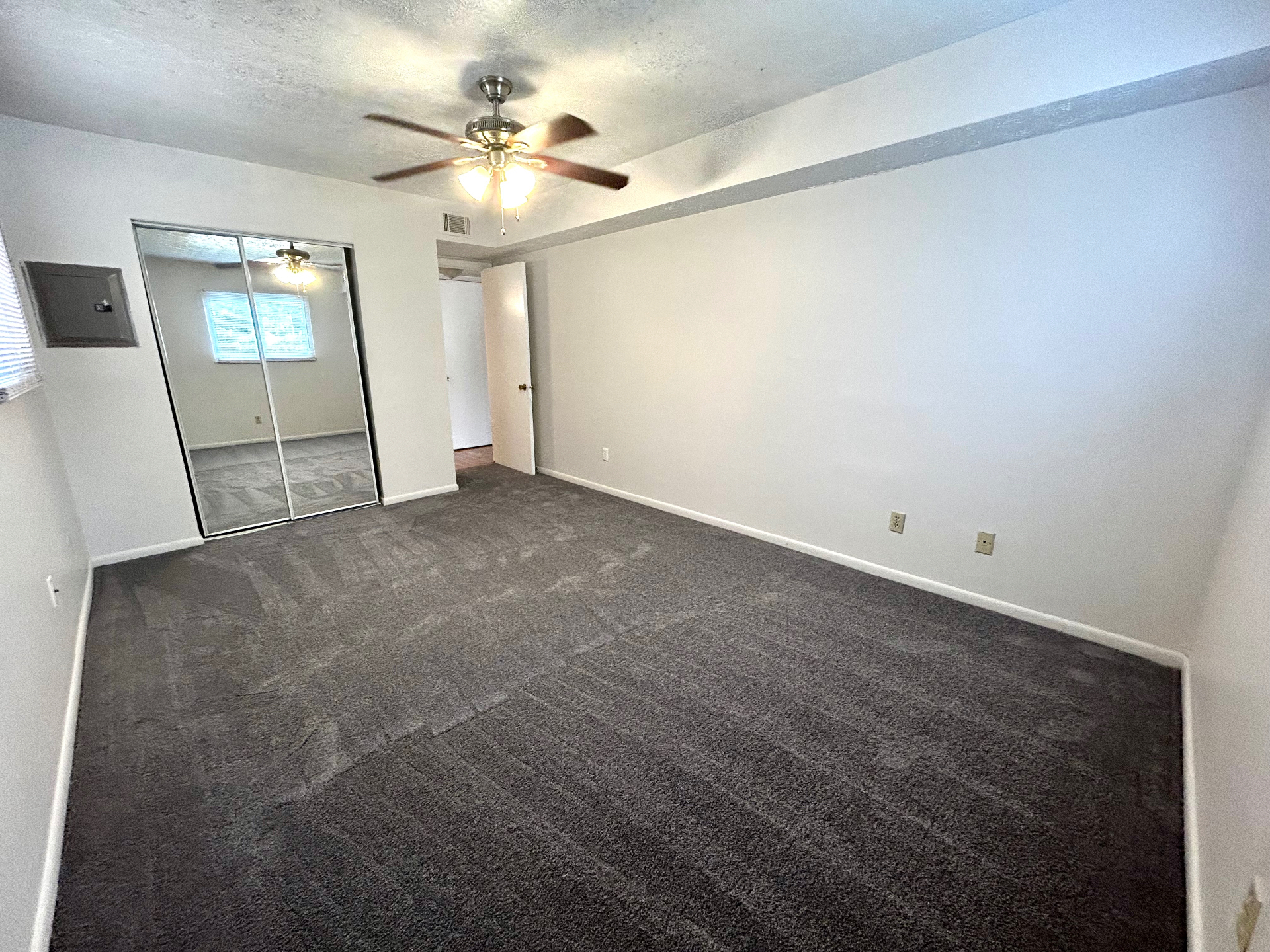 2150 N 4th St. Unit C alternate bedroom angle with ceiling fan, mirrored closet, and gray carpet