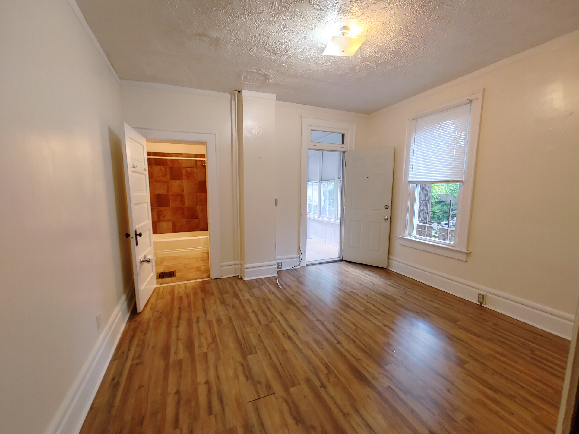 374 A E 14th Ave. back bedroom with plank floors, en-suite bathroom access, and door to rear sunroom