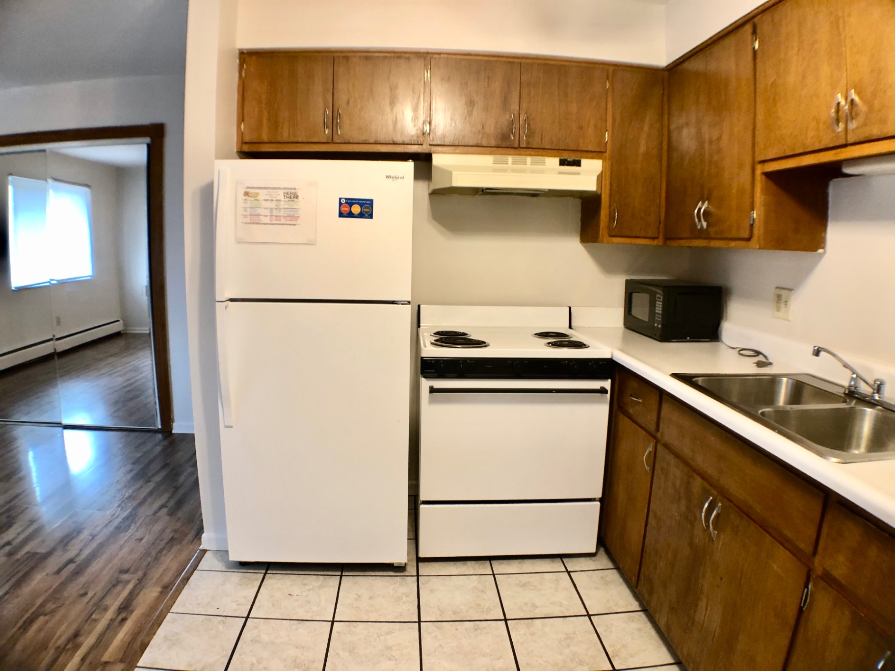 1827 N 4th St. Unit 4 kitchen with white appliances, gas range, and view into bedroom