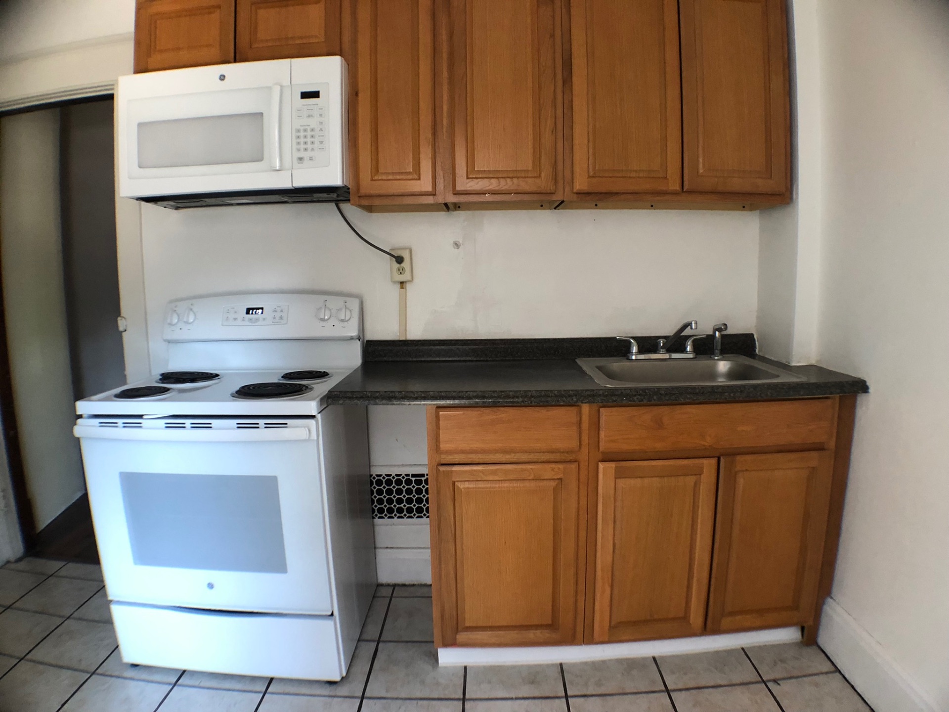 1814 Summit St. kitchen with maple cabinets, electric range, microwave, and tile floor