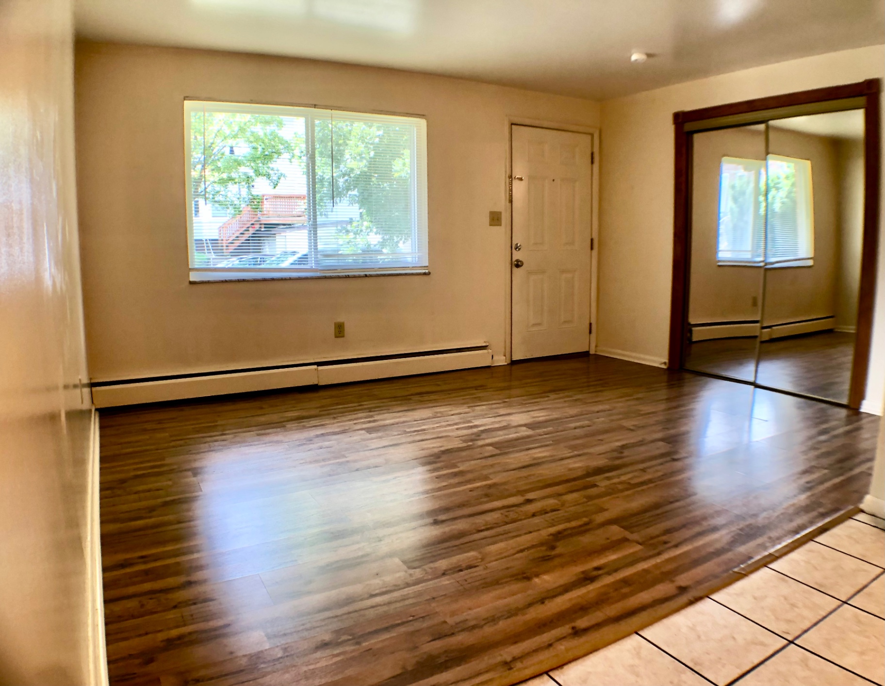 1827 N 4th St. Unit 1 living room with wood-look flooring, large window, and mirrored closet