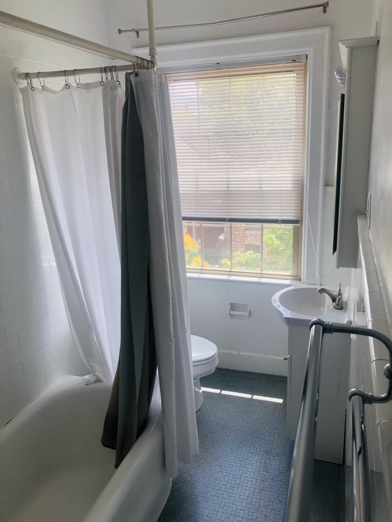 Unit K bathroom with clawfoot tub, pedestal sink, and large window