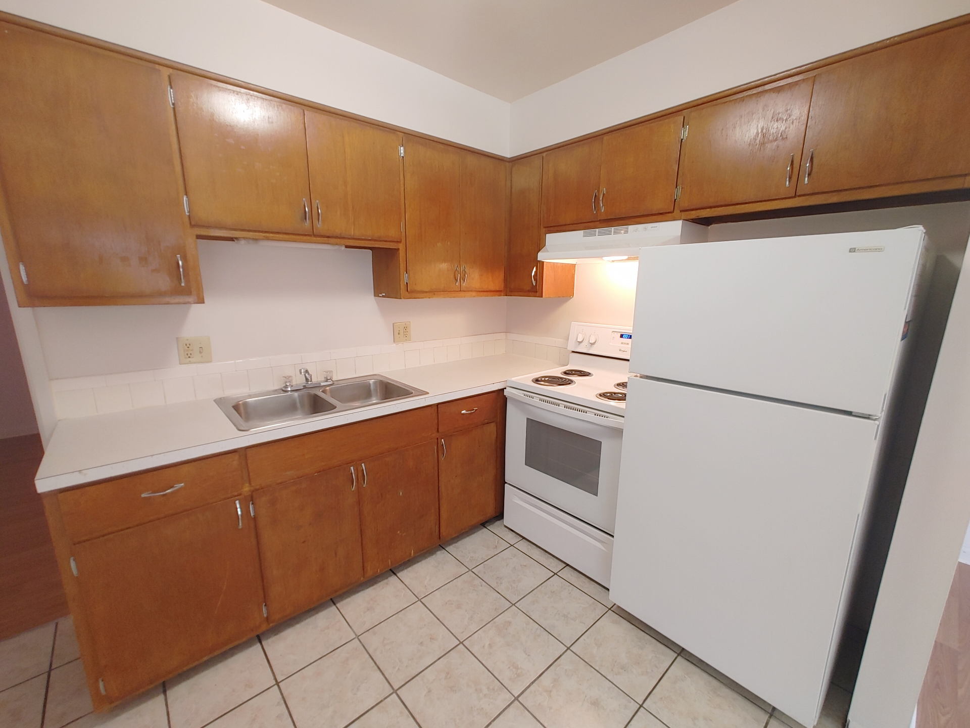 1827 N 4th St. Unit 5 kitchen with oak cabinets, white fridge, electric range, and double sink
