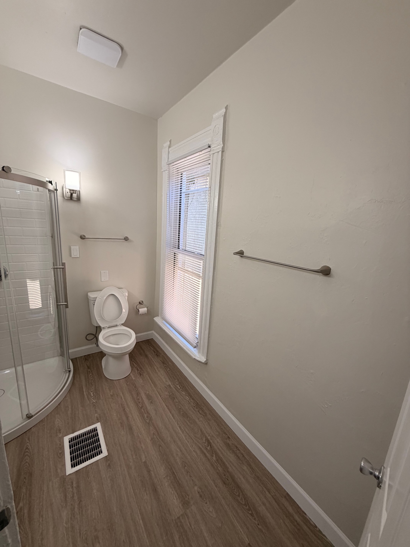 133½ bathroom with plank flooring, glass shower and bright window