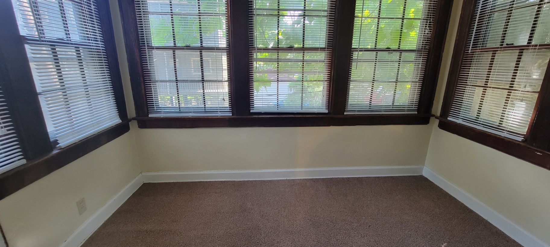 2044 Iuka Ave. D sunroom with wraparound dark-trim windows and treetop views