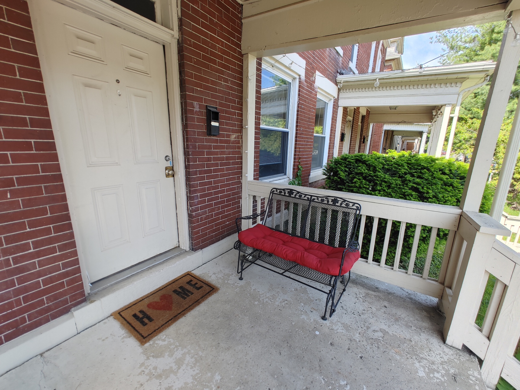 117 W 9th covered front porch with bench and welcome mat
