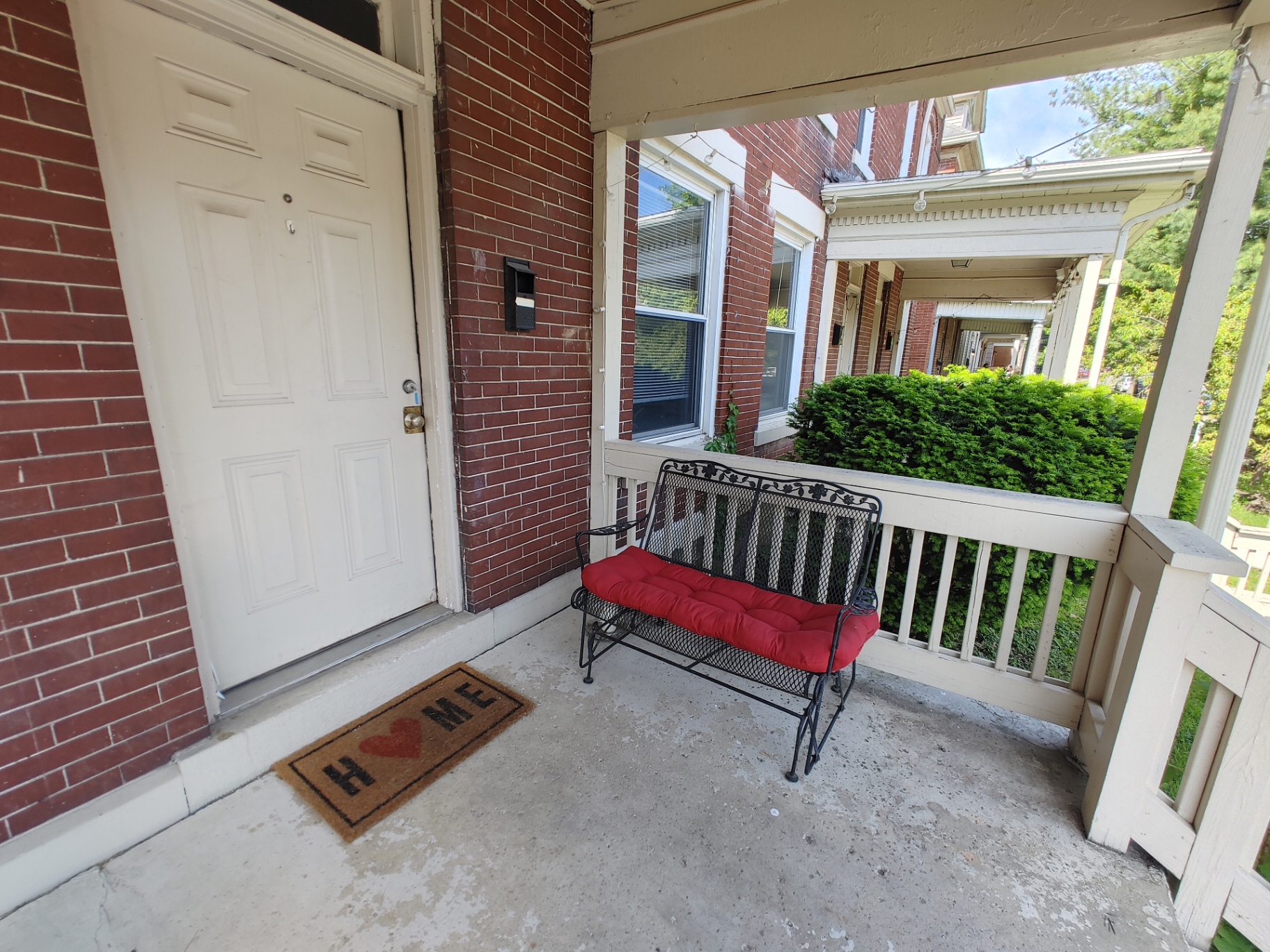 121 W 9th covered brick front porch with wrought iron bench