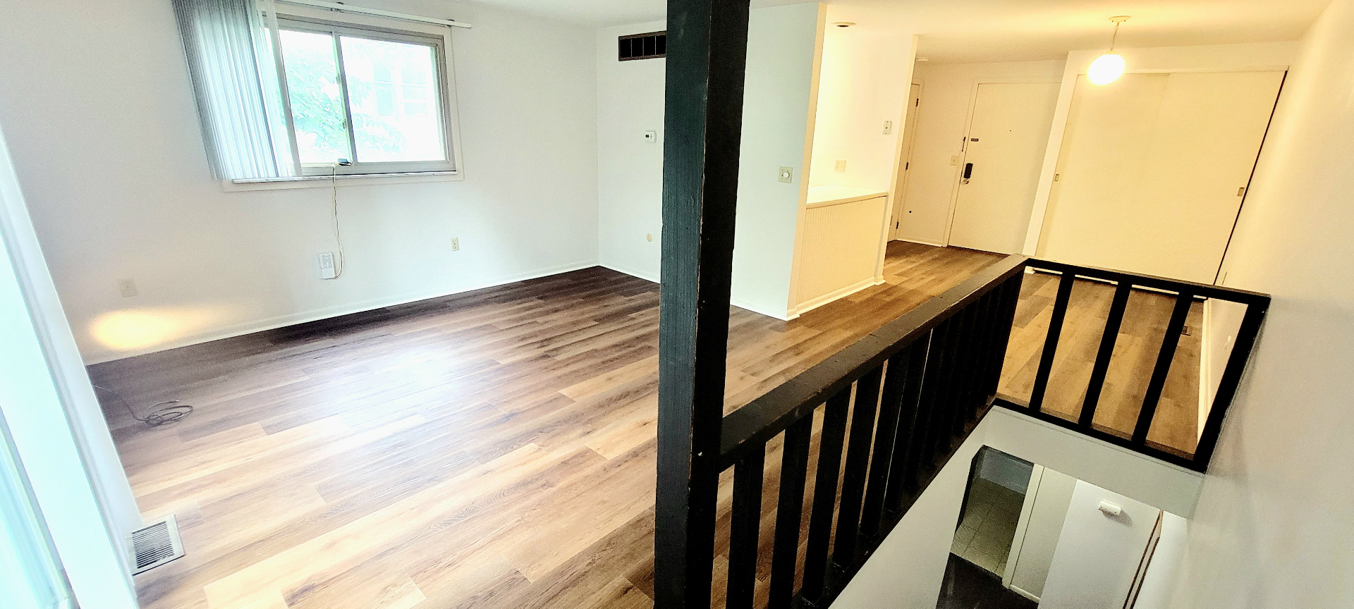 2022 Summit St. upper-level living area with picture window, open stair, and continuous plank flooring
