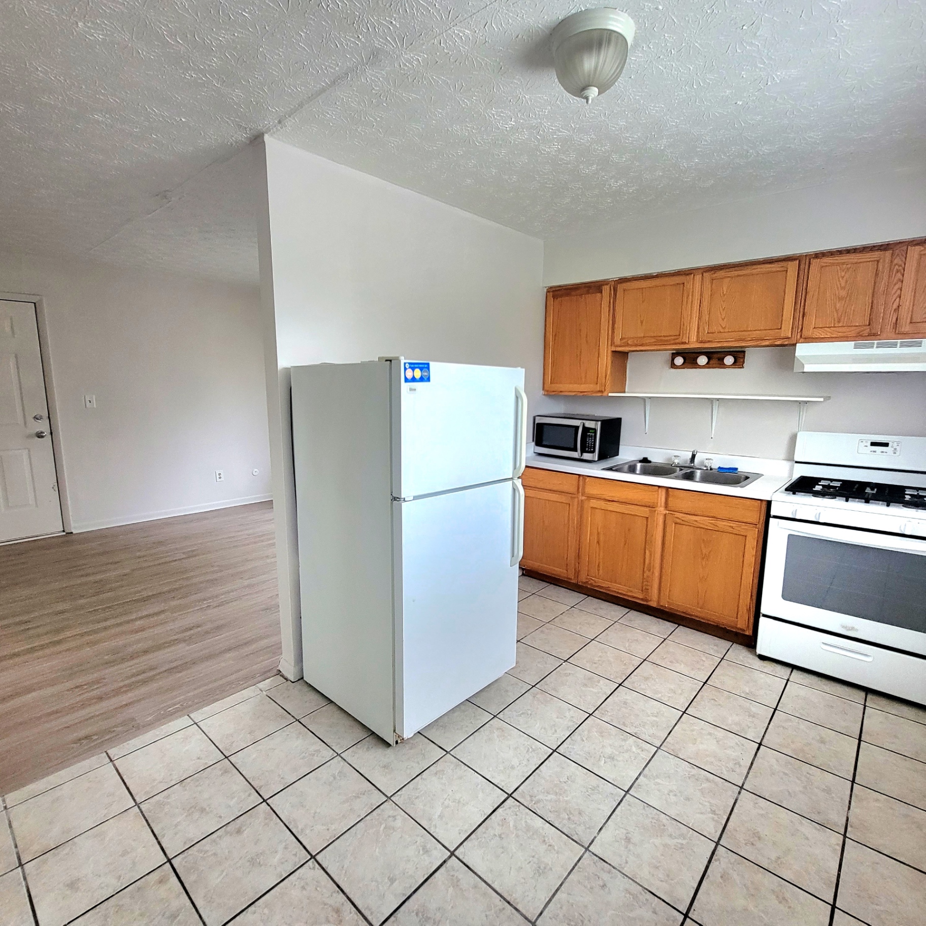 2150 N 4th St. Unit E open kitchen with gas range, oak cabinets, and view into living area