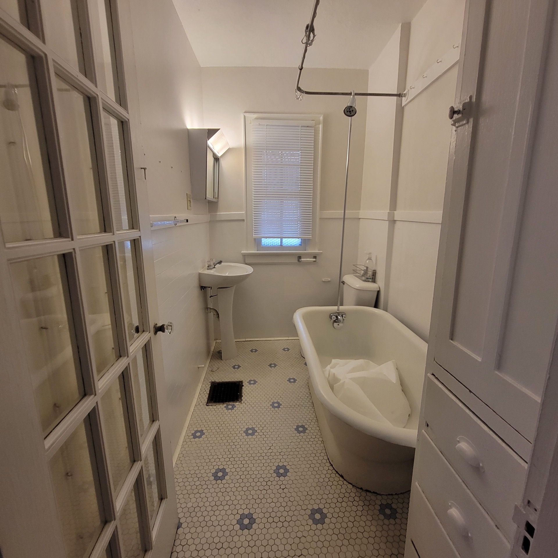 2048 Iuka Ave. C full bath with clawfoot tub, pedestal sink, and hex tile floor