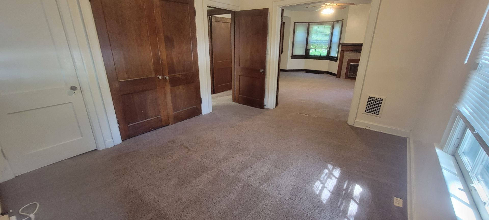 2054 Iuka Ave. A interior hallway with original wood doors and view to living room fireplace