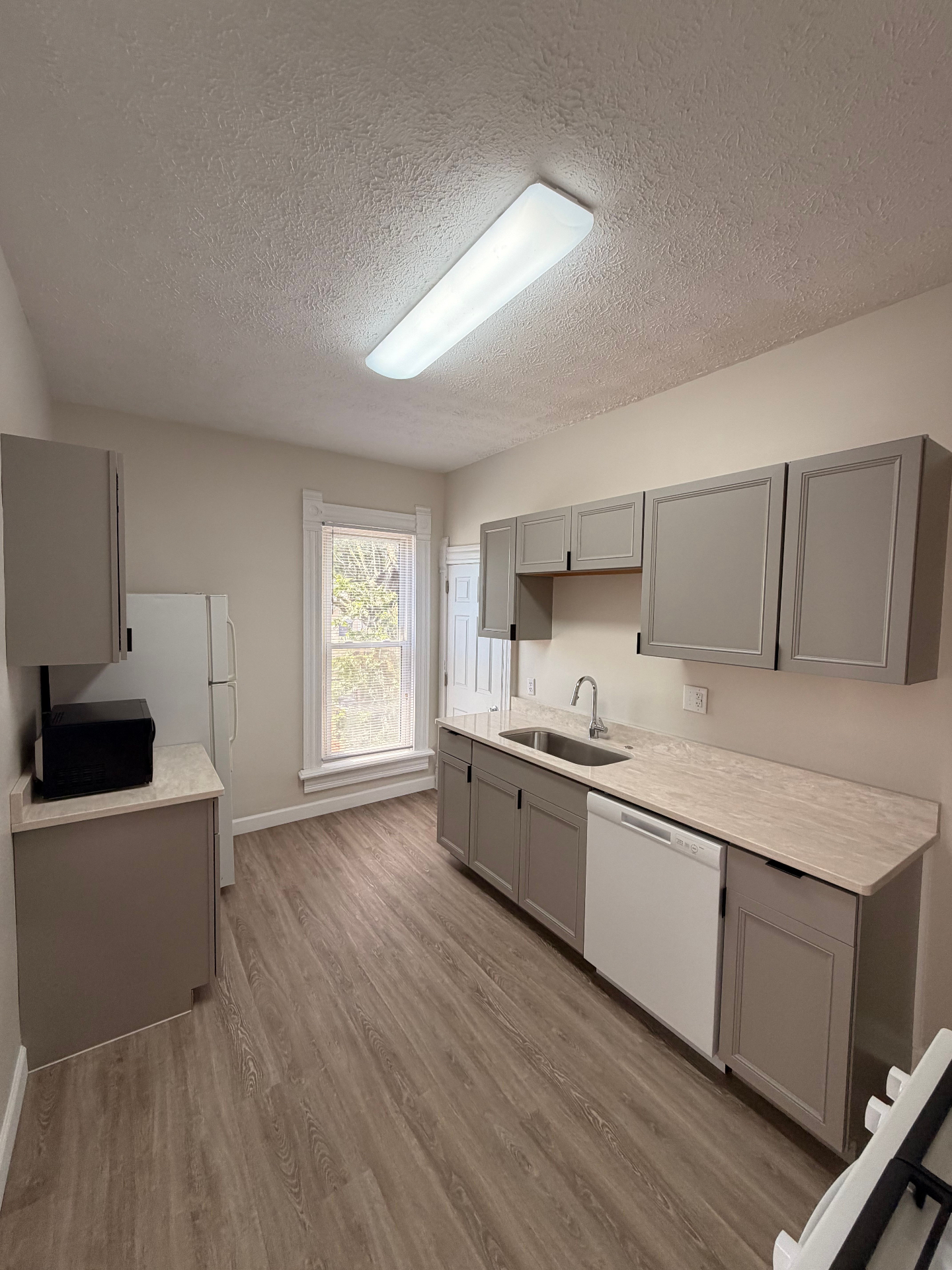 133½ renovated kitchen with grey cabinets, quartz counters and stainless sink