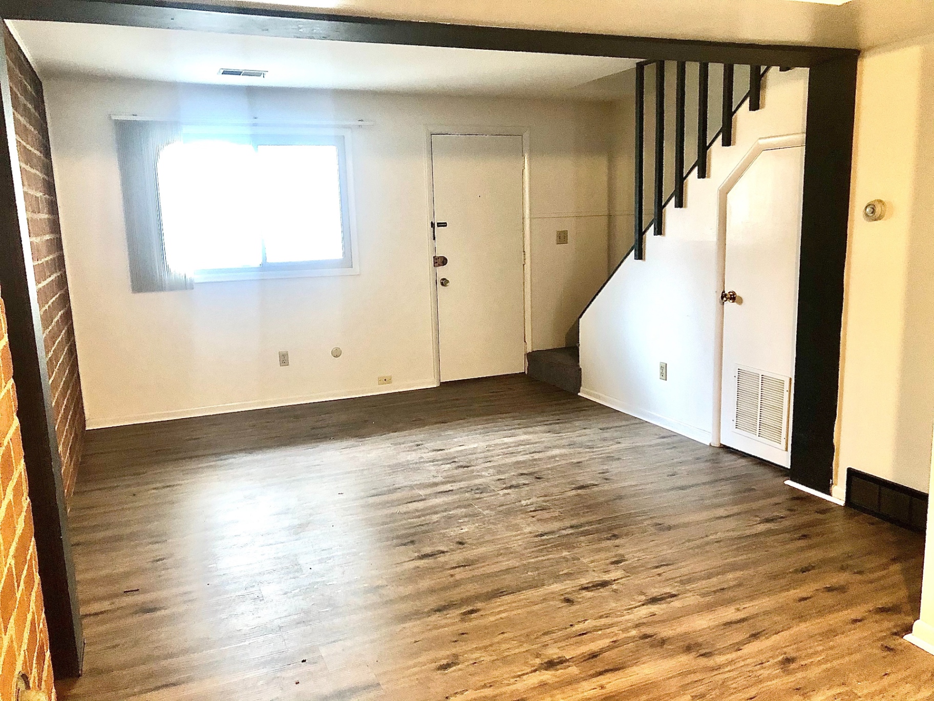 2011 Summit St. Unit A open living/dining area with plank floors, front door entry, and staircase
