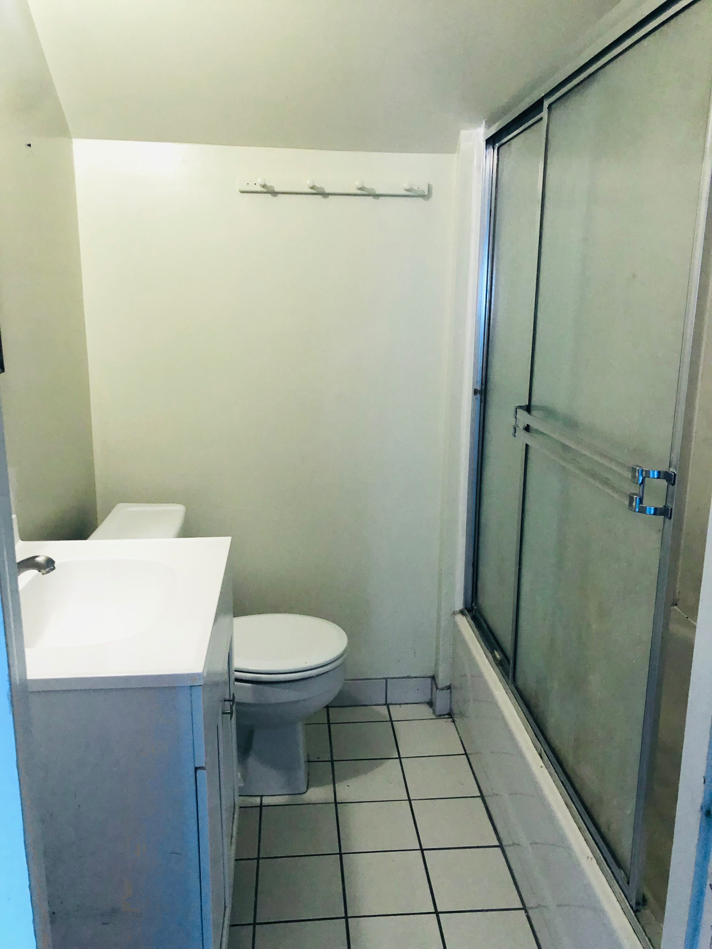 2005 Summit St. bathroom with white vanity, toilet, and sliding glass shower doors