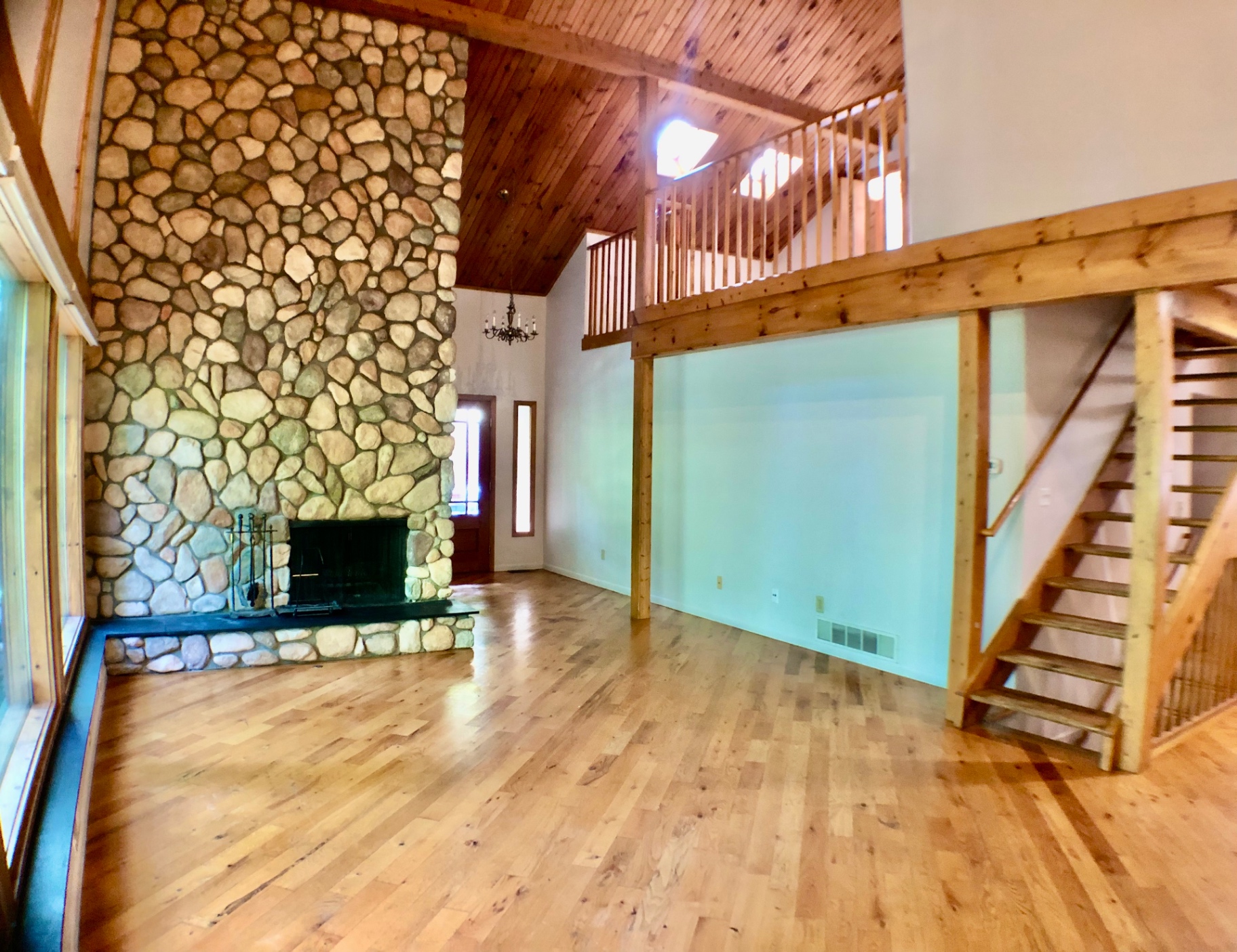 2040 Iuka Ave House great room with river-stone fireplace and open loft above