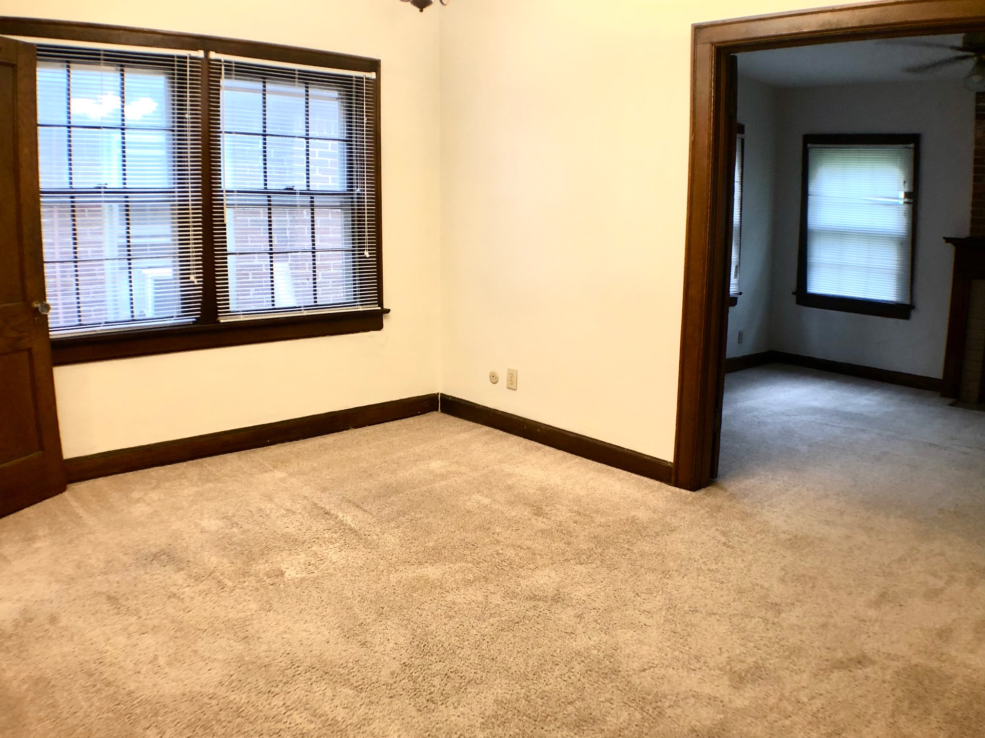 2054 Iuka Ave. D carpeted room with original dark wood trim and open doorway into the adjoining living space