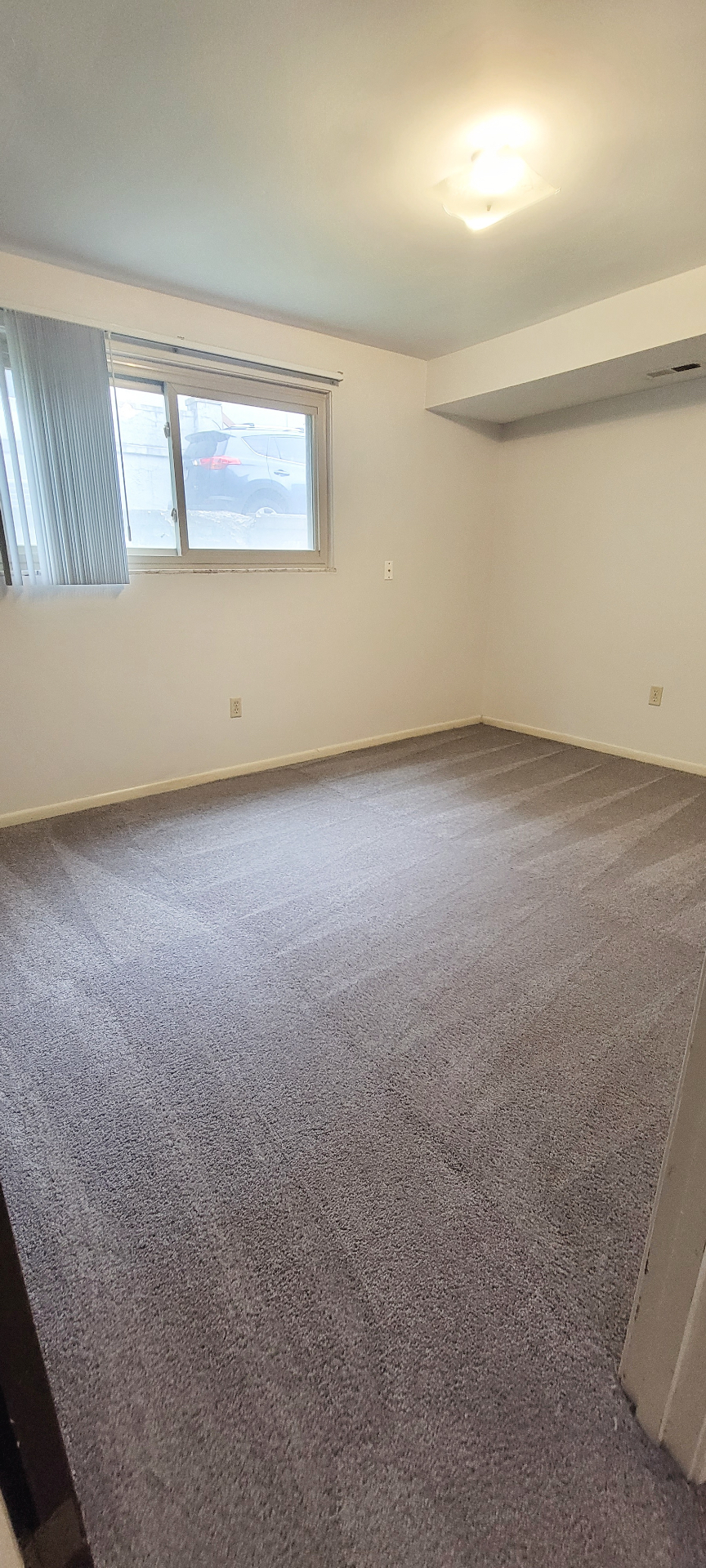2024 Summit St. carpeted bedroom with broad window and recessed ceiling detail