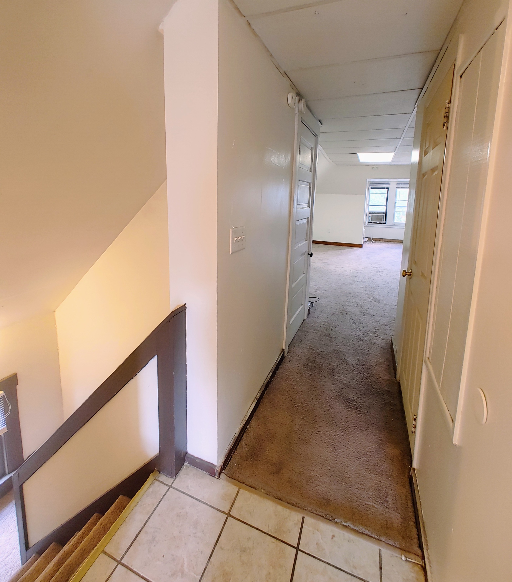 89 E Woodruff Ave. Unit C interior hallway with tile entry, private stairwell, and access to carpeted rooms