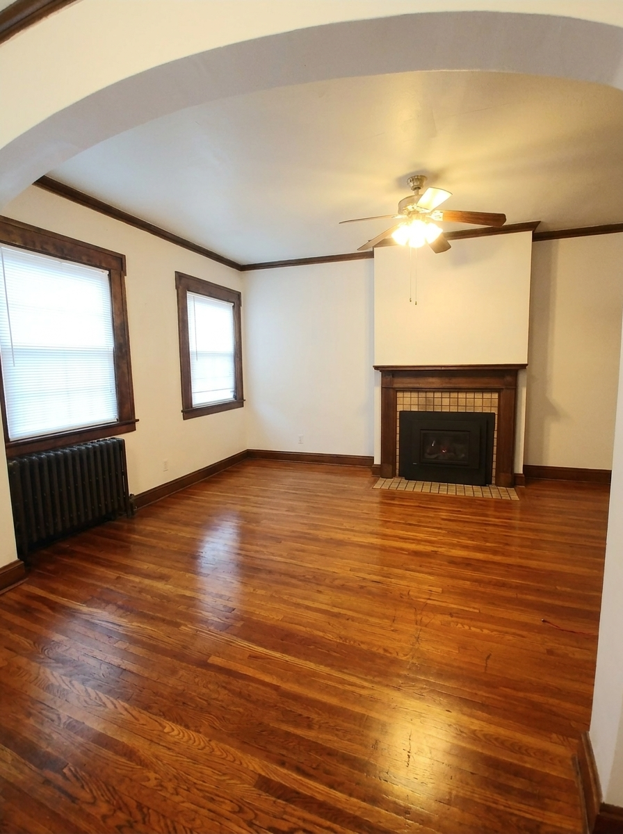 Unit C living room with fireplace, archway, and dark wood trim