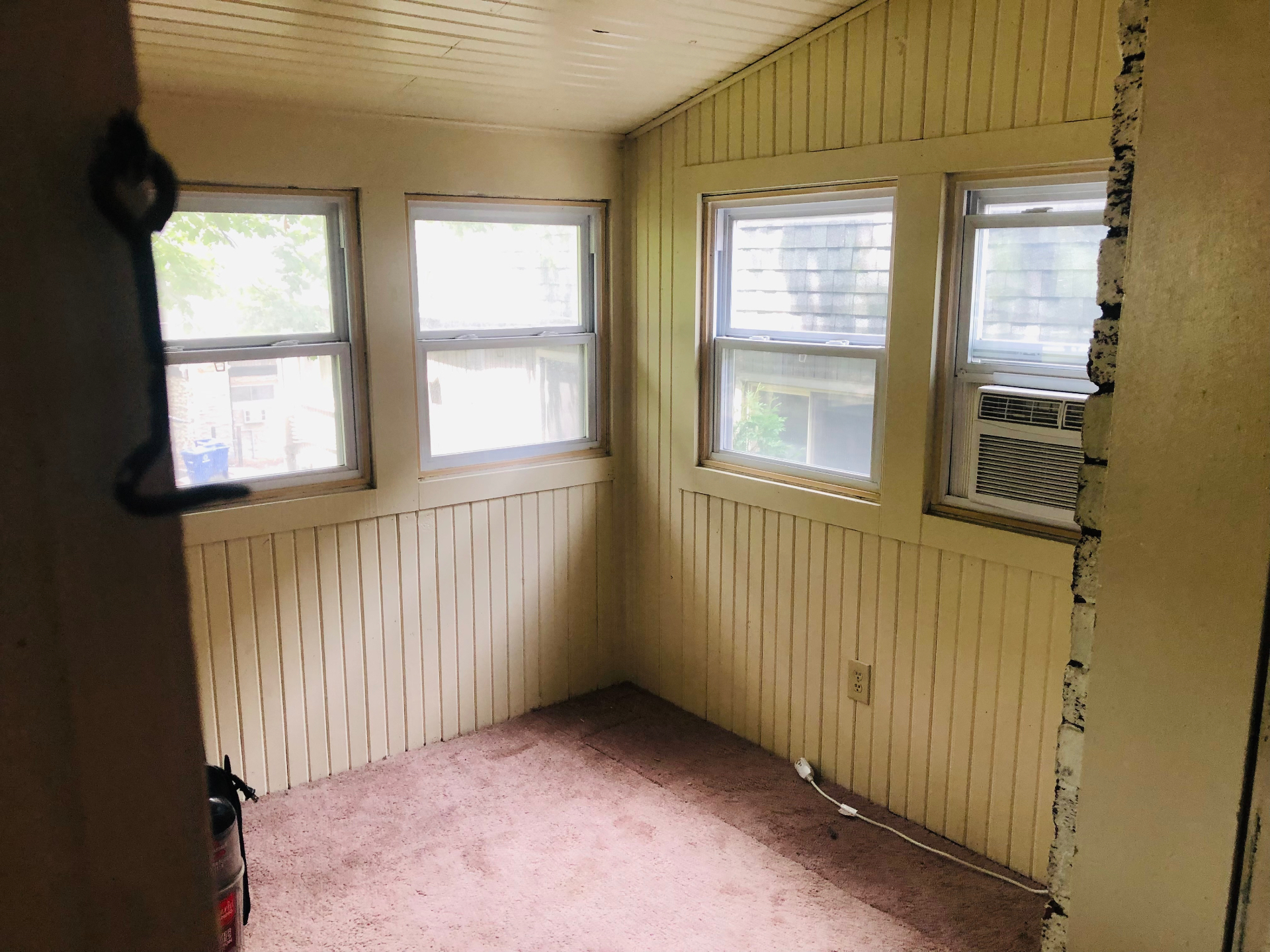 2005 Summit St. bright sunroom with wraparound windows and beadboard walls