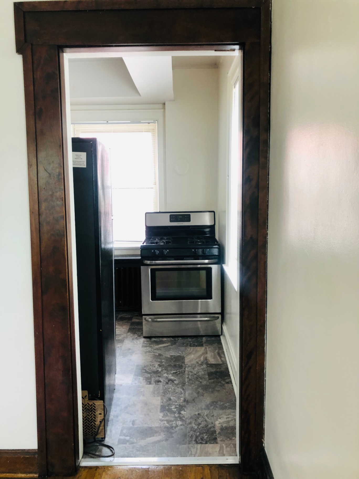 Unit F kitchen view with stainless steel gas range and dark wood trim