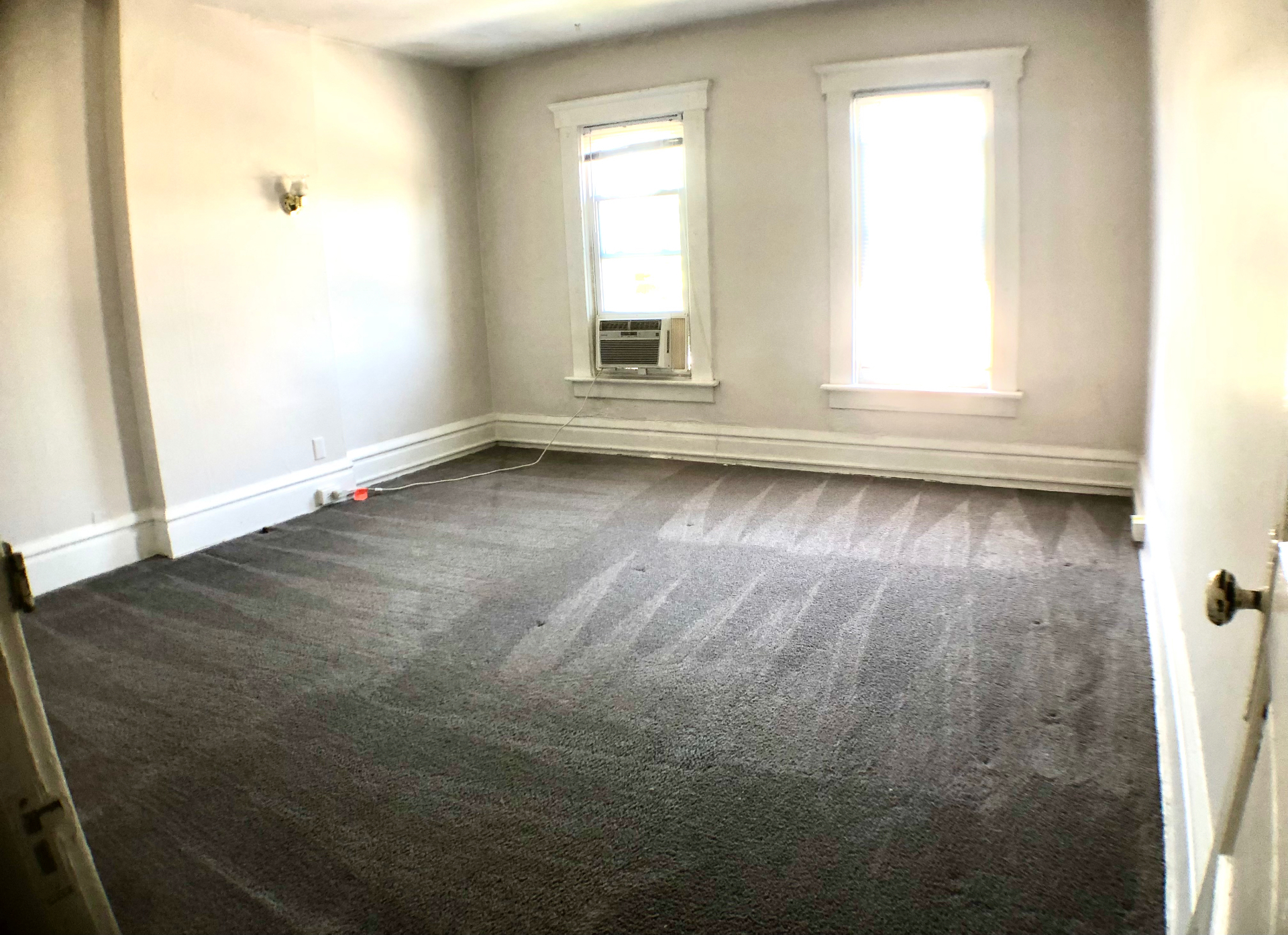 117 W 9th bedroom with fresh grey carpet and two bright windows