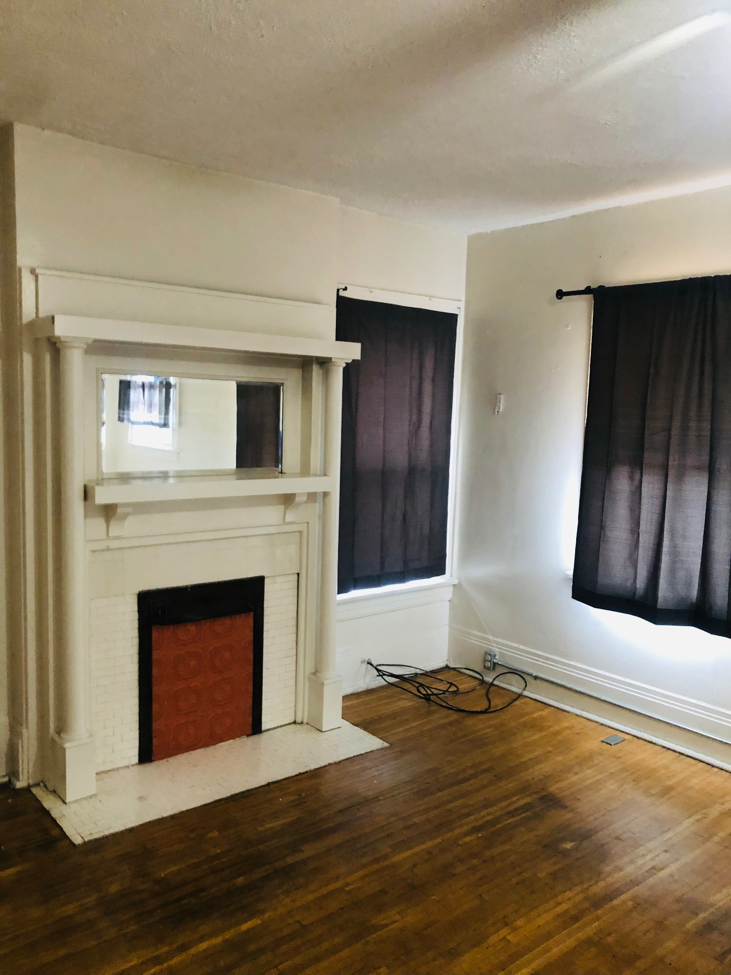 2005 Summit St. living room with white Craftsman mantel, built-in mirror, and hardwood floors