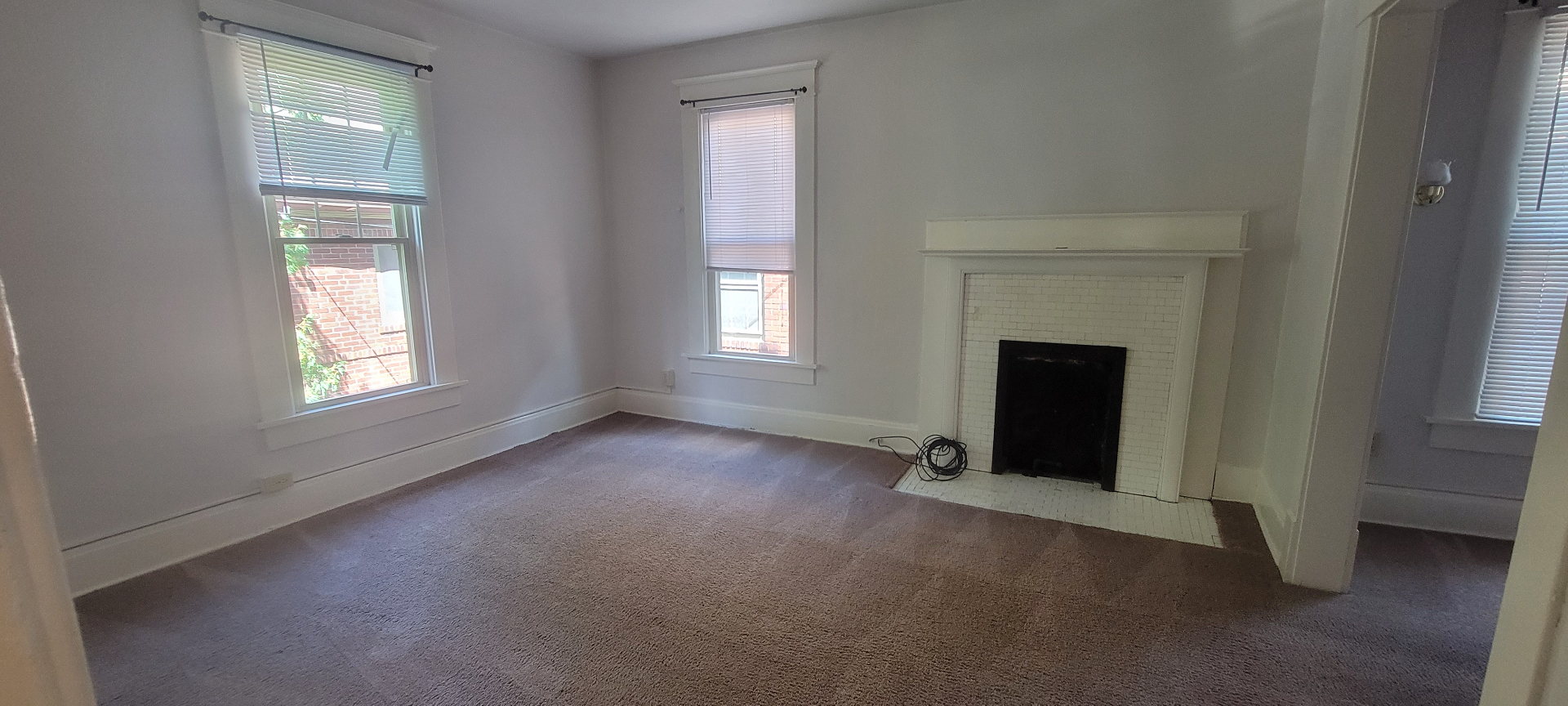2015 Summit St. upstairs bedroom with white tile fireplace, carpet, and tall windows
