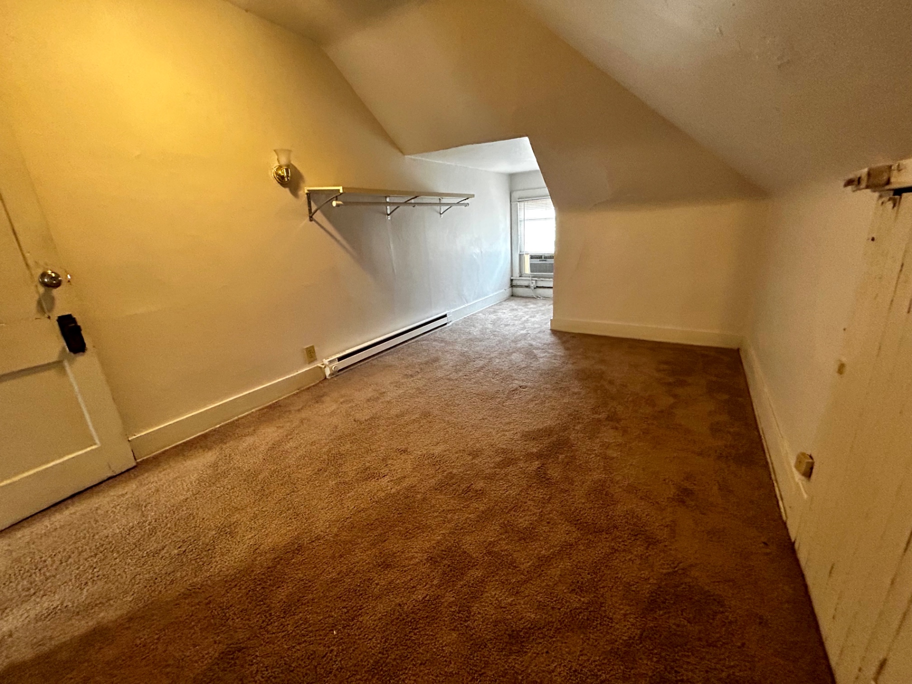 1820 Summit St. upper room with sloped ceilings, fresh carpet, and bright window AC nook