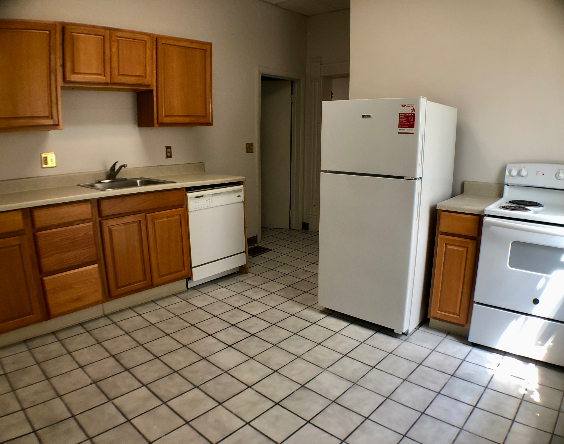 Unit A eat-in kitchen with maple cabinets, dishwasher, full-size fridge and electric range