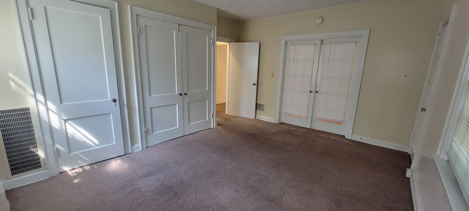 2044 Iuka Ave. D bedroom with double closet and French-door entry, plush carpet, and lots of natural light