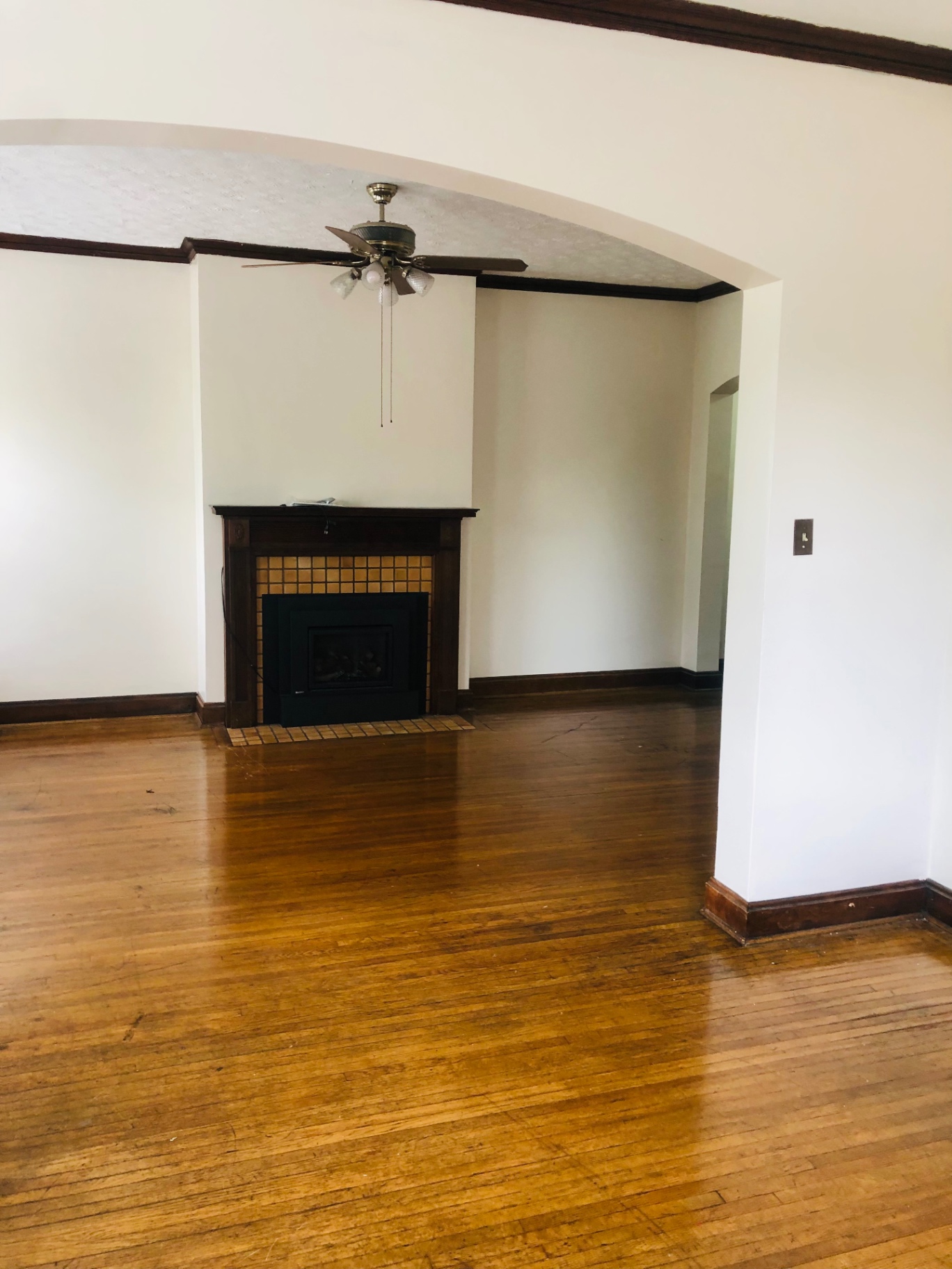 Unit F living room with gas fireplace, tile surround, and hardwood floors