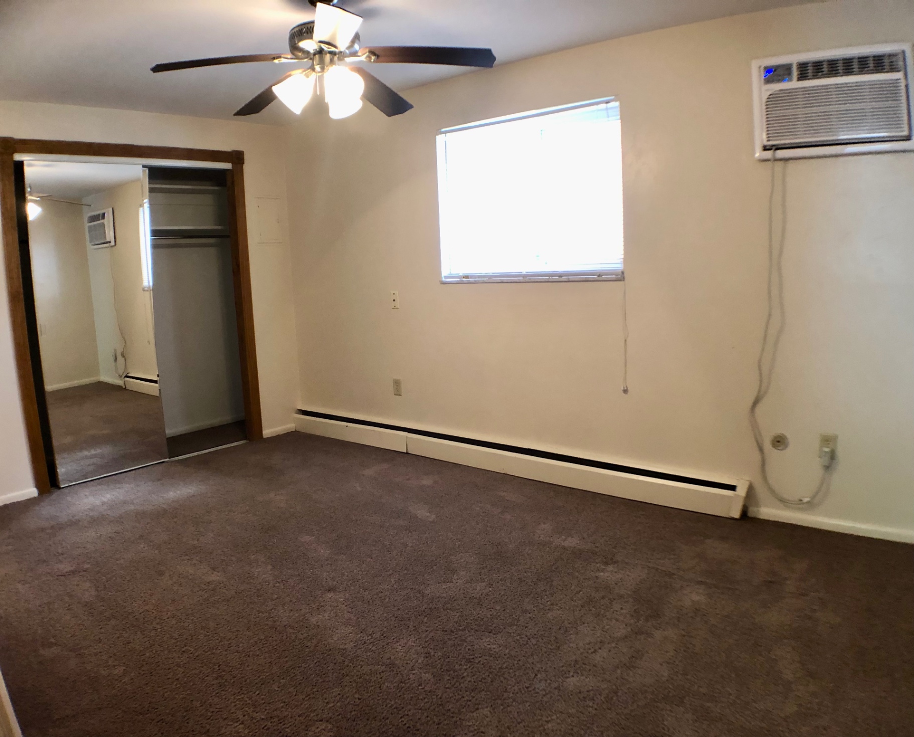 1827 N 4th St. Unit 1 carpeted bedroom with ceiling fan, closet, and window AC