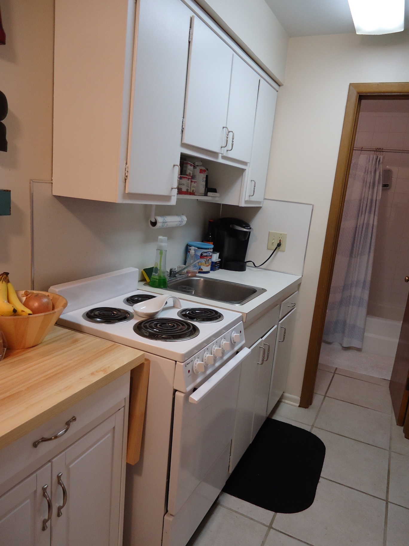 2040 Iuka Ave. 4B kitchen with white cabinets, electric range, and tile floor