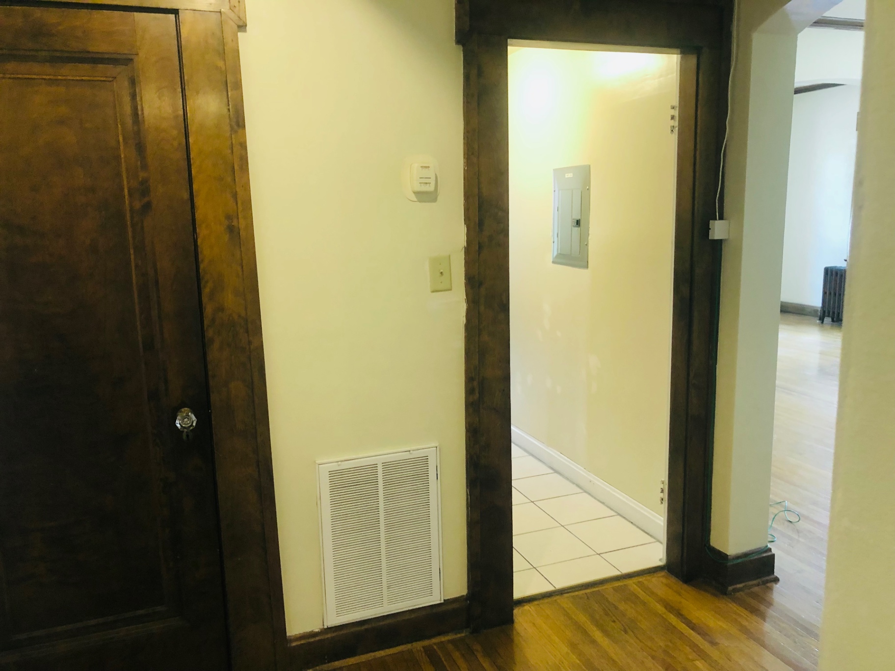Unit K interior entry with dark wood trim and hallway to bathroom