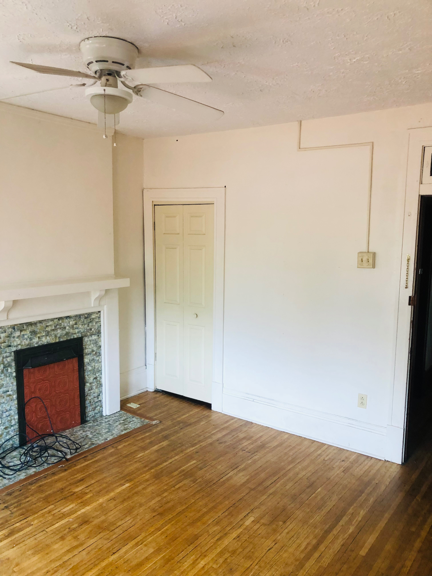 2005 Summit St. living room fireplace wall with hardwood floors and ceiling fan