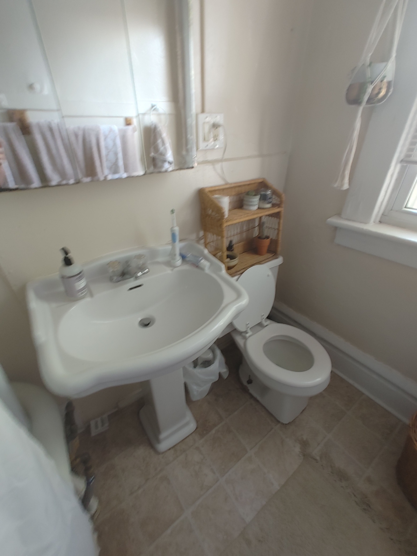121 W 9th bathroom with pedestal sink, tile floor, and bright window