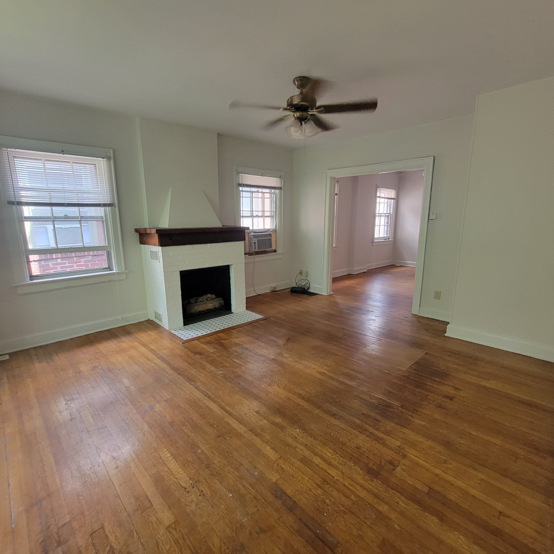 2048 Iuka Ave. C living room with fireplace, ceiling fan, and bright front windows