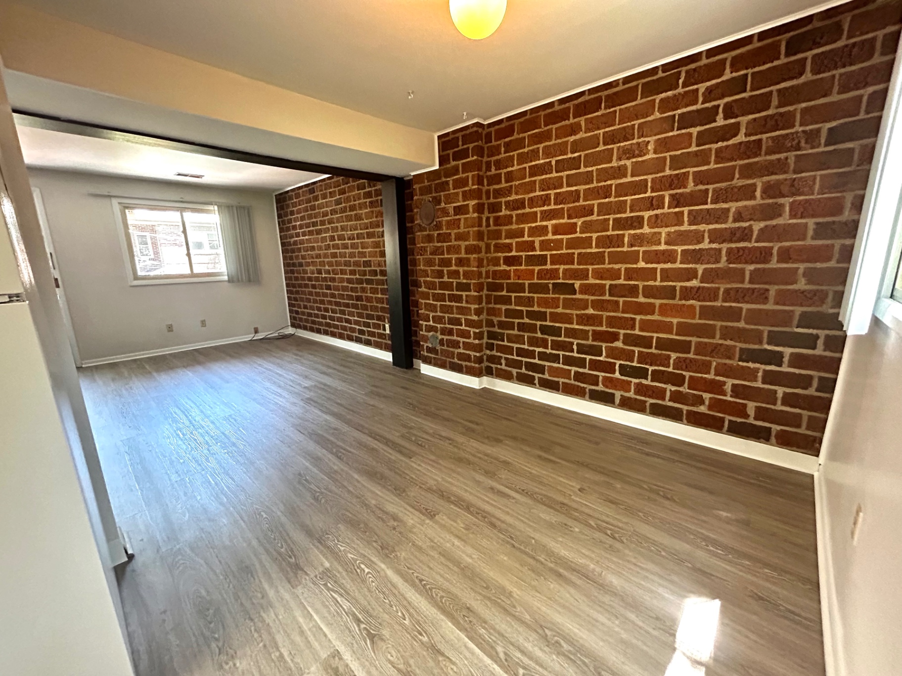 2011 Summit St. Unit E bright bedroom with exposed brick accent wall and plank flooring