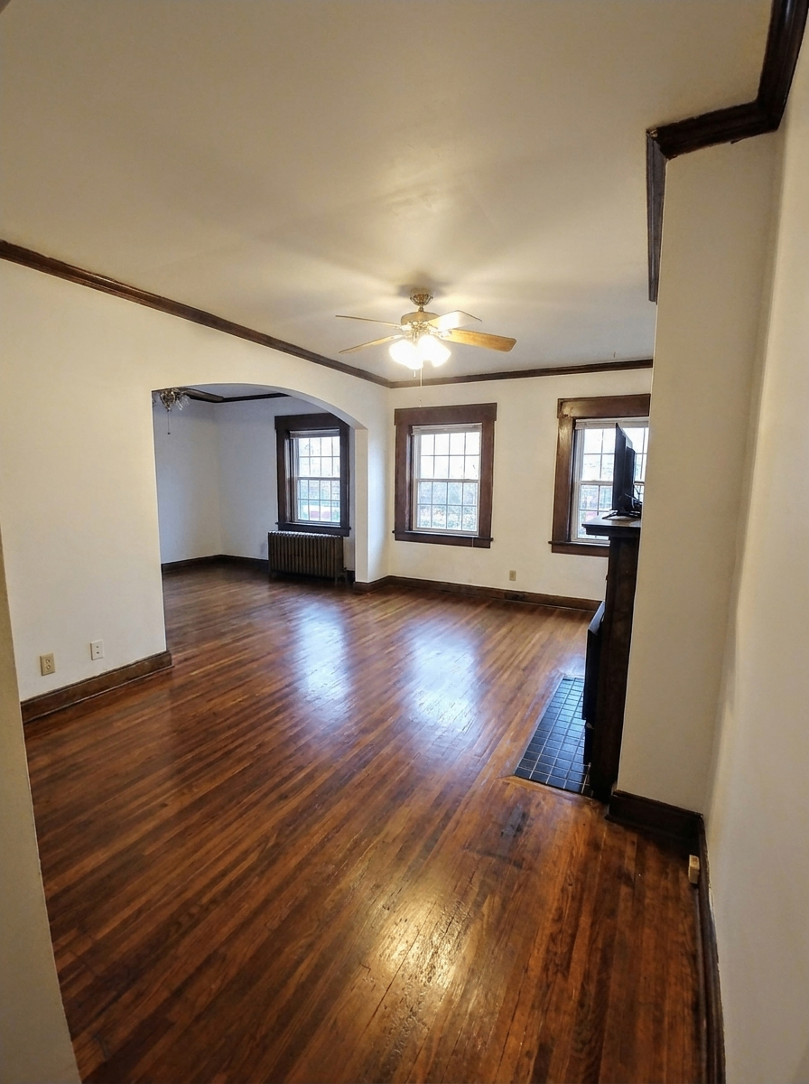 Unit B living and dining area with hardwood floors, archway, and multiple windows