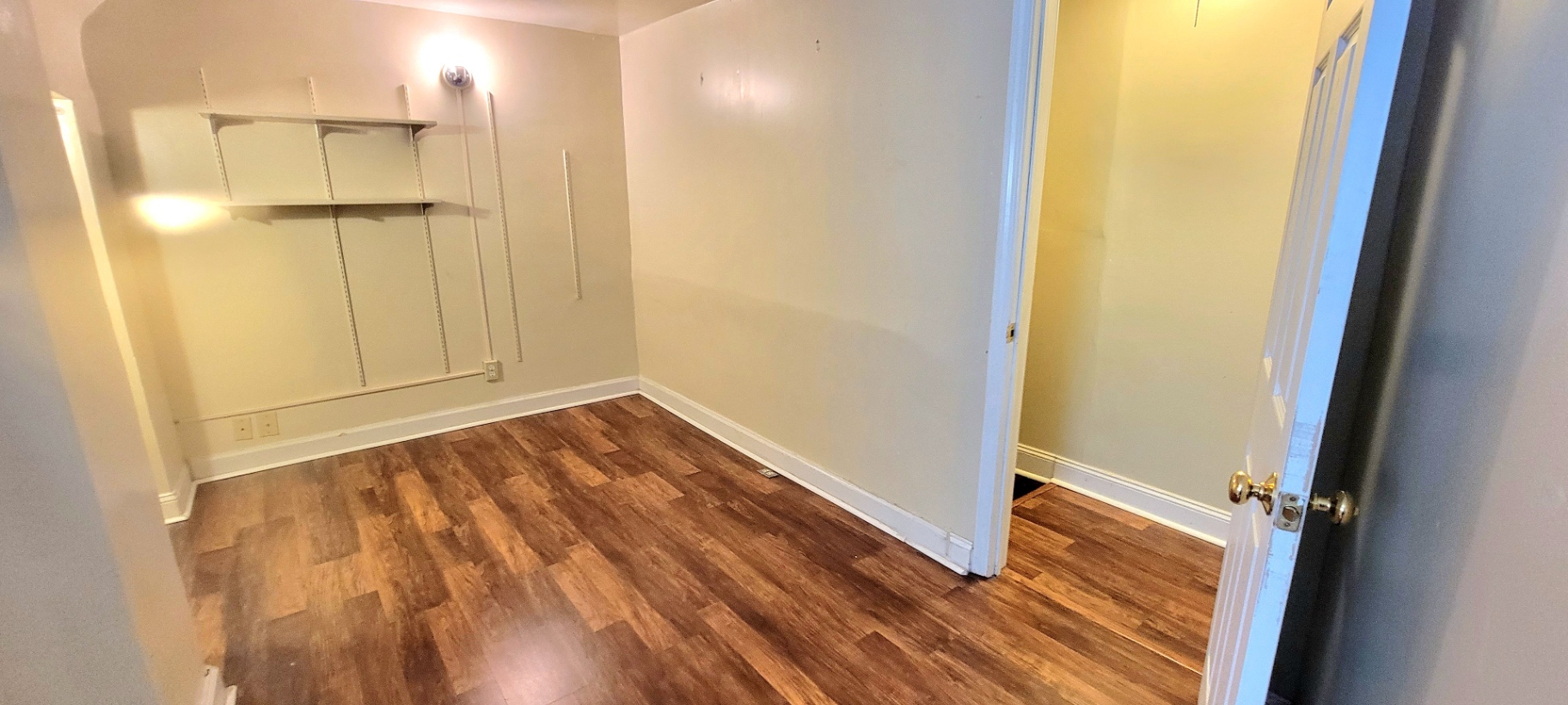 2044 Iuka Ave. D upper-level bedroom with adjustable wall shelving and warm wood-look flooring