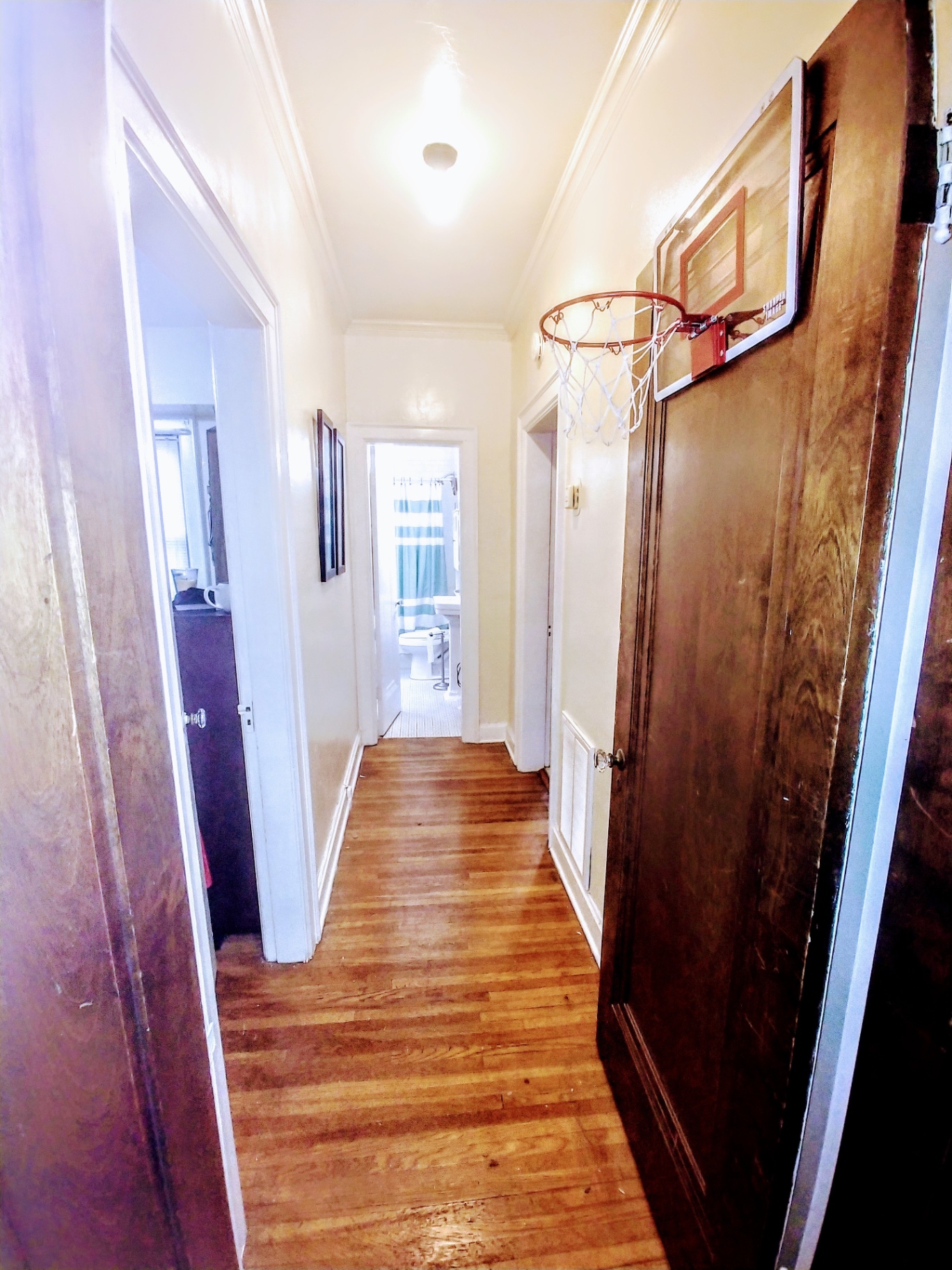 Unit L hallway with hardwood floors looking toward the bathroom